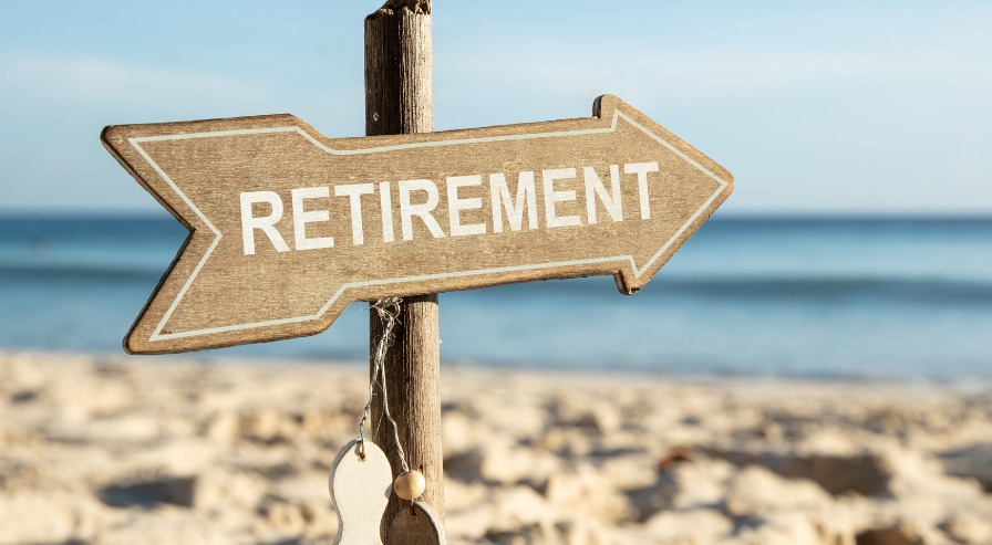 A signboard by the seashore with 'Retirement' written on it, symbolizing a calm and stable retirement journey.