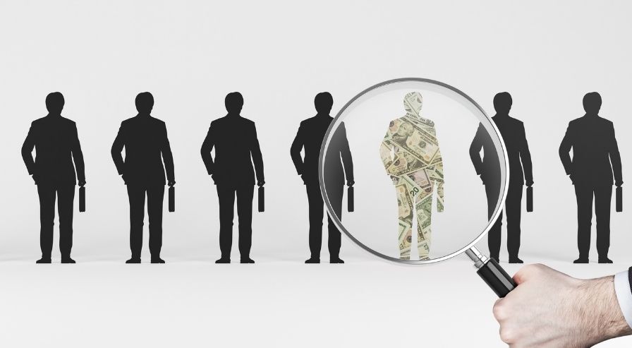 Silhouettes of six business professionals with briefcases, one highlighted with a magnifying glass, representing the search for a financial advisor.