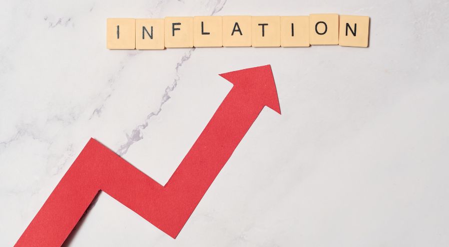 INFLATION spelled out with letter tiles at the top, with a red upward arrow below indicating an increase.